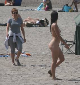Topless girl goes full-nudist at textile beach  Almeria (Spain)-c6x556qj1s.jpg